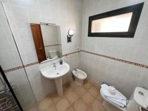 a bathroom with a sink and a toilet at Anahi Home Corralejo - Villa Cardon 12 in La Oliva +6 photos