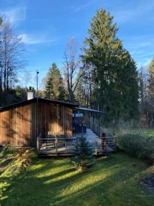 a wooden cabin with a deck in the grass at Herzhütte Für Zwei in Vichtenstein