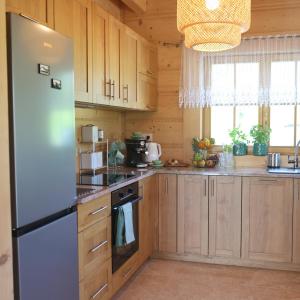 een keuken met houten kasten en een koelkast bij Leśny Zakątek Zawoja in Stryszawa +21 foto's