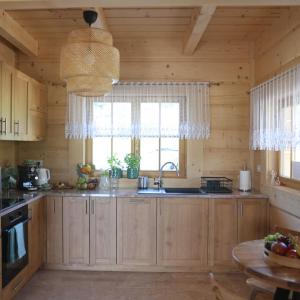 een keuken met houten kasten, een wastafel en een raam bij Leśny Zakątek Zawoja in Stryszawa