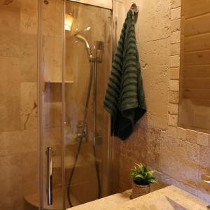 een douchecabine met een groene handdoek aan de muur bij Leśny Zakątek Zawoja in Stryszawa