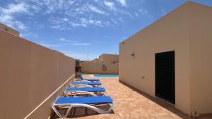 a row of chaise lounges on the side of a building at Anahi Homes Corralejo- Dracaena 18 in La Oliva