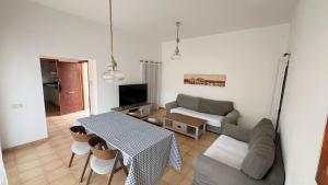 a living room with a table and a couch at Anahi Homes Corralejo- Dracaena 18 in La Oliva