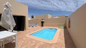 a swimming pool in the middle of a patio at Anahi Homes Corralejo- Dracaena 18 in La Oliva