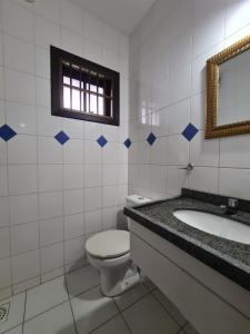 un bagno con un water, un lavandino e uno specchio di Casa perto da praia - Frente para Lagoa a Garopaba Altre 14 foto