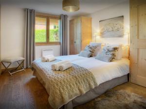 a bedroom with a large bed with towels on it at Chalet Edenalpa - OVO Network in La Clusaz +10 photos