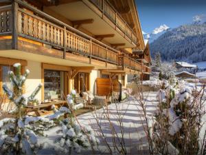 a house with a deck in the snow at Chalet Edenalpa - OVO Network in La Clusaz