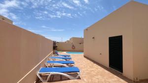eine Reihe von Chaiselongues auf dem Dach eines Gebäudes in der Unterkunft Anahi Homes Corralejo- Dracaena 20 in La Oliva