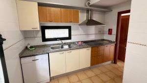 eine kleine Küche mit weißen Schränken und einer Spüle in der Unterkunft Anahi Homes Corralejo- Dracaena 20 in La Oliva