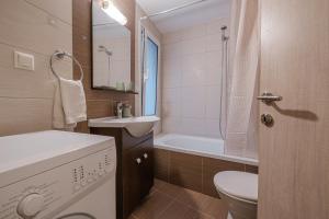 a bathroom with a sink and a toilet and a tub at Porto Blu - Sea View Apartment in Kos Town +11 photos