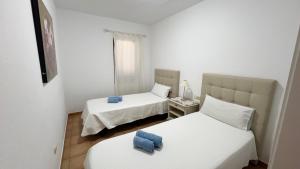 a room with two beds and a table with a mirror at Anahi Homes Corralejo - Villa Drago 12 in La Oliva +13 photos