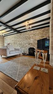 un soggiorno con un divano e un tavolo con bicchieri da vino di Ffoswen Pembrokeshire Holiday Home a Boncath