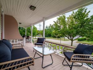 a porch with chairs and a couch and a table at Historic District w Fully Stocked Kitchen and Sleeps 6 in Bedford