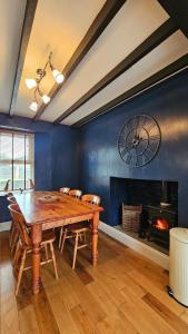 una sala da pranzo con tavolo in legno e camino di Ffoswen Pembrokeshire Holiday Home a Boncath