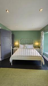 una camera da letto con un letto con una parete verde di Ffoswen Pembrokeshire Holiday Home a Boncath