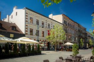 a city street with tables and chairs and buildings at Piotrkowska 89 Residence in Łódź