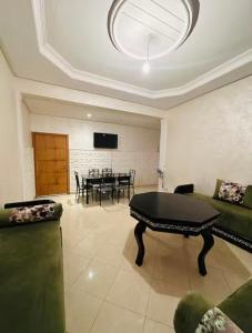 ein Wohnzimmer mit Tisch und Couch in der Unterkunft Appartement lumineux in Mohammedia