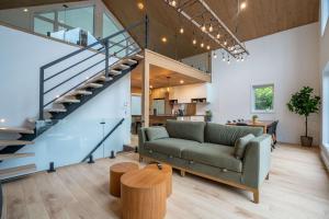 a living room with a couch and a staircase at Spa Babyfoot Total comfort - Le Chouette Chalet in Saint-Donat-de-Montcalm