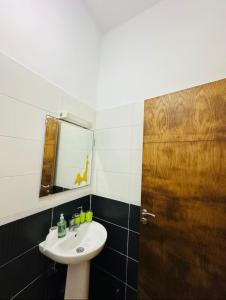 ein Badezimmer mit einem Waschbecken und einer Holztür in der Unterkunft Appartement lumineux in Mohammedia