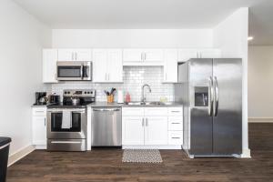 a kitchen with stainless steel appliances and white cabinets at SpringBrook Lofts in Alcoa