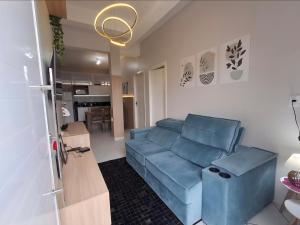 a living room with a blue couch and a kitchen at Ap Cabernet 2 in Bento Gonçalves