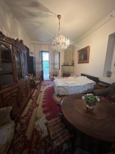 Un dormitorio con una cama, una mesa y una lámpara de araña. en Исторический частный дом, en Kobuleti 20 fotos más
