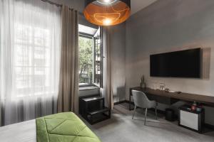 a bedroom with a desk and a television and a bed at BRYK Hotel - Maestro in Odesa