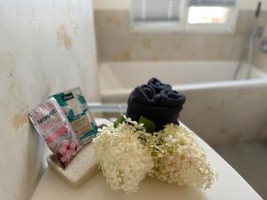 a bathroom with a sink with flowers and a bath tub at Casa Hortensia in Ettenheim