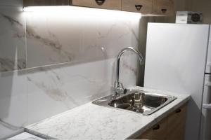 a kitchen with a sink and a white counter top at Floran's Apartments in Ermoupoli +34 photos