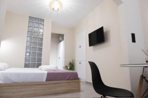 a bedroom with a bed and a desk and a chair at Floran's Apartments in Ermoupoli