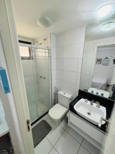 a bathroom with a white toilet and a sink at Manhattan Beach Riviera 202 By AM in Aquiraz