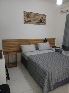 une chambre avec un lit avec une couverture à carreaux dans l'établissement Pousada Parque Suites- Estacionamento e Piscina na enseada, à Guarujá 63 autres photos