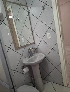a bathroom with a sink and a mirror and a toilet at Ap Cabernet 2 in Bento Gonçalves +24 photos