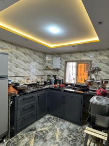タガズートにあるBest house in taghazoutの黄色の天井のキッチン(黒いキャビネット付)