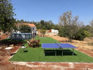 a ping pong table and chairs on a lawn at Private Pool Fazenda Terrace Villa in Silves