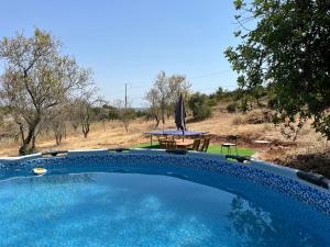 a swimming pool with a table and a umbrella at Private Pool Fazenda Terrace Villa in Silves