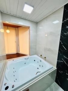 a bathroom with a large tub in a room at Charmê Chalés in Campos do Jordão +15 photos