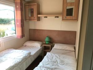 Saint-Nazaire-sur-CharenteにあるMobil Home 40 M², Proche De La Merの窓のある小さな部屋にベッドが2つある