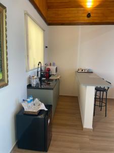 a kitchen with a counter and a table in a room at Charmê Chalés in Campos do Jordão