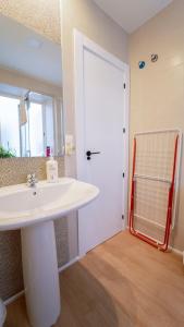 格拉纳达Piso Taracea的浴室里有白色洗手池和镜子 更多17张照片