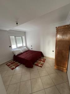a bedroom with a bed and a window in a room at Residence avec piscine in Martil