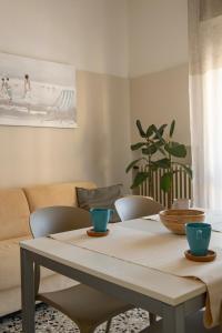 a dining room table with chairs and a couch at Residence Valeria in Cervia