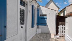 an alley with a blue door and a fence at Petite maison CHATELNANON à 250 mètres de la mer in Châtelaillon-Plage