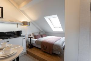 a bedroom with a bed with a window and a table at Avanti Villa in Kraków