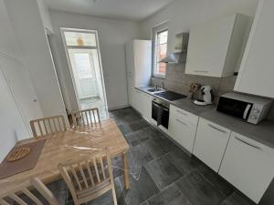 a kitchen with a table and chairs and a microwave at Maison typique in Le Neubourg