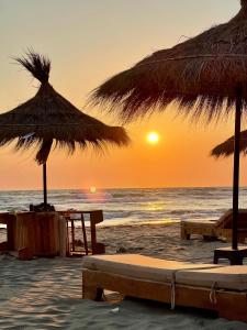 a beach with umbrellas and chairs and the ocean at San Pietro Premium Meliá Garden Apartment in Lalzit Bay