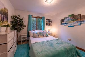 a bedroom with a bed and a dresser and a window at Horseshoe Acres - Home theater, spa room, hot tub in Oak Hill