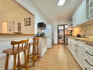 cocina grande con armarios blancos, mesa y sillas en Viva la Vida, en Los Realejos