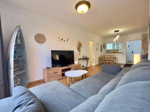 Una sala de estar con un sofá azul y un televisor. en Viva la Vida, en Los Realejos