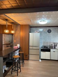 a kitchen with a white refrigerator and wooden cabinets at 癒しの宿鎌野 in Takamatsu +20 photos